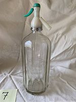 Full vintage Magda soda water seltzer bottle with green and white dispenser top shown upright