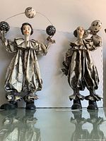 Pair of vintage Italian paper mache clown figurines standing side by side showing full bodies with costumes and wire with balls.