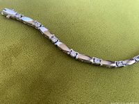 Close-up showing segment of rhodium plated links alternating with cubic zirconia stones.
