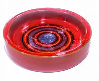 Photo of round red pottery trinket dish with hand painted concentric circles design inside.