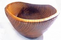 View showing textured teak wood grain and asymmetrical shape of the bowl