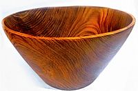 Front angle view of the large teak wood salad bowl showing its curved shape and wood grain.