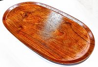 Photo showing top and front side of mid century teak tray with natural grain and smooth polished surface.