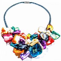 Front angled view of the multi-color mother of pearl necklace showing clustered segments and pearl accents on braided cord.