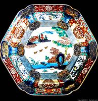 Top view of the octagonal vintage Asian hand painted plate showing intricate landscape and floral designs.