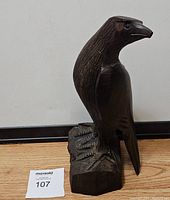 Side view of the carved ironwood bird sculpture showing detailed feathers and beak.