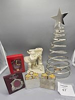 Full view of all Christmas decor items including Godinger salt and pepper shakers, Mikasa Santa figurine, metal spiral candle tree, and boxed ornaments.