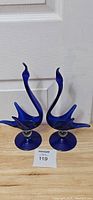 Pair of cobalt blue blown glass swans positioned upright, showing front and side profile.