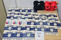 View of 33 View-Master reels in paper sleeves spread out with two View-Master viewers (black and red) behind them on a wooden surface