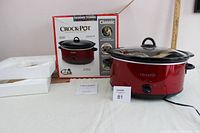 Full lot displayed with crockpot, box, styrofoam insert, and manual on table