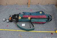 Side view of golf bag with golf clubs inside showing overall set length and condition of bag.