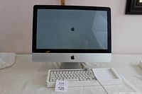 Front view of 2011 Apple iMac computer with wired keyboard in original box beneath it.