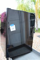 Front view of black glossy Insignia mini-fridge showing minor surface blemishes.