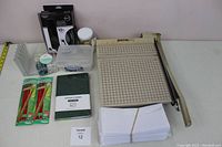 Full view of all items including Boston 2612 paper cutter, planner, pencils, envelopes, and various office accessories.