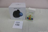 Front view showing unopened Symbodii Vertiball massage ball box and unopened music player box together on a table.
