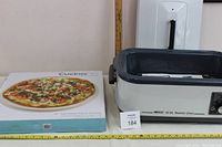 Photo showing the Nesco roaster oven next to the CucinaPro pizza stone box with a pizza image