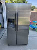 Exterior view of stainless steel side-by-side refrigerator showing dual doors and integrated water dispenser