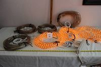 View of six coiled rope light sections on table, three illuminated and plugged in to demonstrate working condition, arranged with tags and connectors visible.