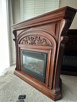 Front view of Febo electric fireplace showing carved wooden mantel and flame display