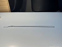 Full length view of the 20 inch silver chain necklace laid flat on a white surface showing entire chain from end to end.