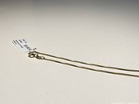 Close-up of the necklace chain showing the fine gold-plated links, clasp, and Shahi Jewelry tag.