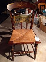 Full front view of the chair showing cane seat, painted scene and decorative frame.