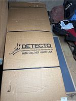Top view of two large brown cardboard boxes stacked, showing the Detecto logo and manufacturing location.