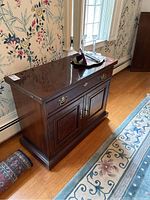 Side and front view of Drexel wood cabinet showing polished wood finish, brass hardware, and overall size.