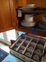 Fabric storage box containing twelve white Wedgwood bone china teacups separated by cardboard dividers