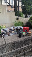 Photo showing nine Funko Pop! figures outdoors, some in boxes and some loose on cement ledge