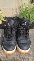 Front view of black Air Jordan Flight shoes showing patterned detailing and gum sole
