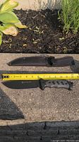 Camping cutter knife with approximately 6 inch blade alongside black protective sheath, blade sharp and unused condition apparent.