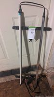 Two fluorescent grow light tubes hanging on wall, one intact one missing bulb