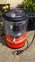 Photo of KitchenAid blender with red base and clear blending container outdoors.