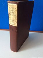 Front view showing spine with title label: 'The Works of Alfred Lord Tennyson' and publication year 1897. Burgundy cloth cover evident with minor wear.