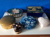 Six decorative boxes arranged side by side against blue background