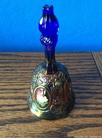 Photo of the side view of the Fenton bell showing the cobalt blue handle and floral decoration on the bell body