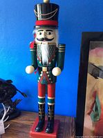 Front view of large wooden nutcracker showing colorful details and height reference.