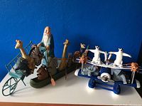 Wooden Noah's Ark canoe gondola with animal figurines and Noah figure on blue background.