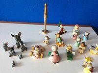 Porcelain mice and miniature Christmas-themed collectibles arranged on table against blue background.