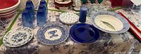 Overview of the entire lot on table showing plates, glasses, serving bowl, and candle