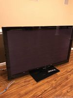 Samsung 63-inch plasma TV showing full front view including screen, bezel, and base stand. Remote control visible on the stand.