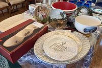Wide view of assortment including decorative plates, platters, serving bowls, and boxed Lenox Winter Greeting divided server.
