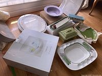 Photo of multiple ceramic serving dishes including boxed Crocus serving bowl and other assorted dishes