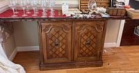 Front view of Thomasville carved wooden buffet showing wood lattice paneling and carved accents on cabinet doors with ring pulls.