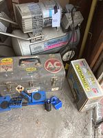 Full view of the Power Pal air compressor next to the metal vintage toolbox with stickers and blue air tool accessories on floor.