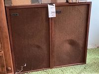Pair of vintage Altec stereo speakers with wooden frames and brown fabric covers. Tags and wear visible.