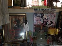 Shot of Johnny Walker mirror with ornate gold and red design, sports themed poster, and liquor bottle base with wooden stopper.