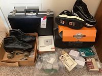 View showing pair of black leather roller skates, black hard briefcase, thermostat box, and assorted electrician supplies