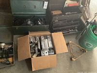 Overview of two open toolboxes, cardboard box and bucket showing lot components